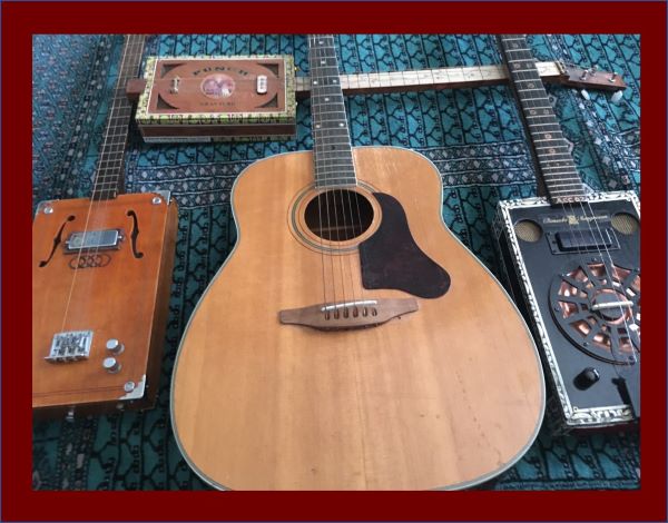 Alan's six-string flat-top and three cigar-box gutars