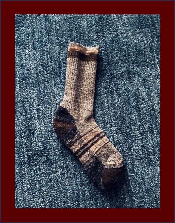 Single unmatched grey sock on a bblue rug