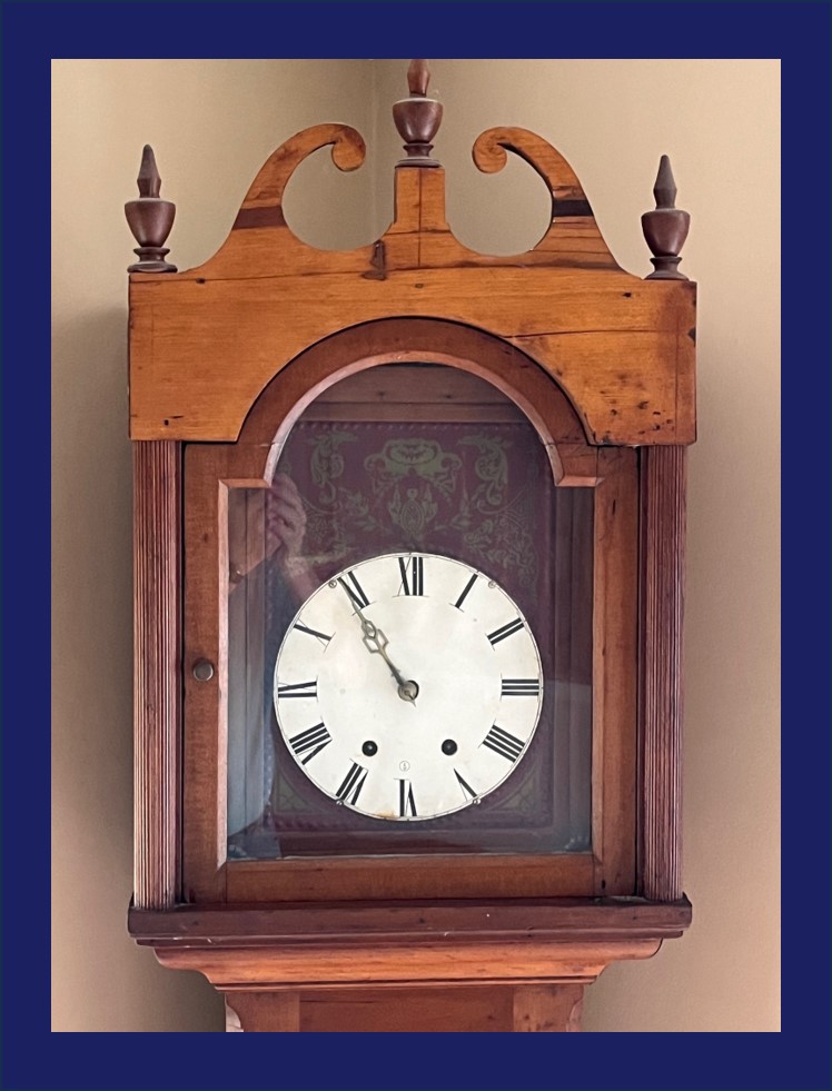 Picture of an old grandfather clock set at five till eleven