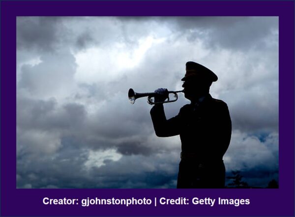 Military Bugler silhouetted against a cloudy sky